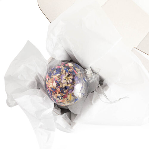 A Christmas confetti bauble in a white gift box