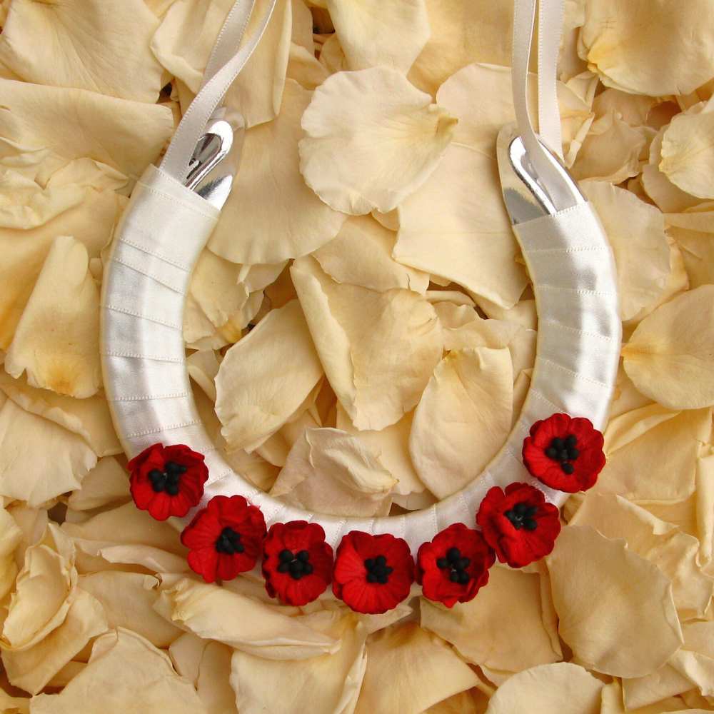 A lucky wedding horseshoe for the bride decorated with red paper poppies.